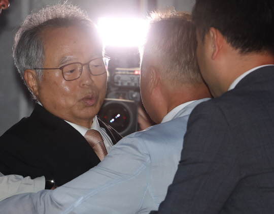 직원을 강제 추행한 혐의로 징역 3년을 선고받은 오거돈 전 부산시장이 26일 만기 출소로 풀려나 부산 사상구 부산구치소를 나서자 지인이 그에게 포옹하며 인사하고 있다.  [연합뉴스]